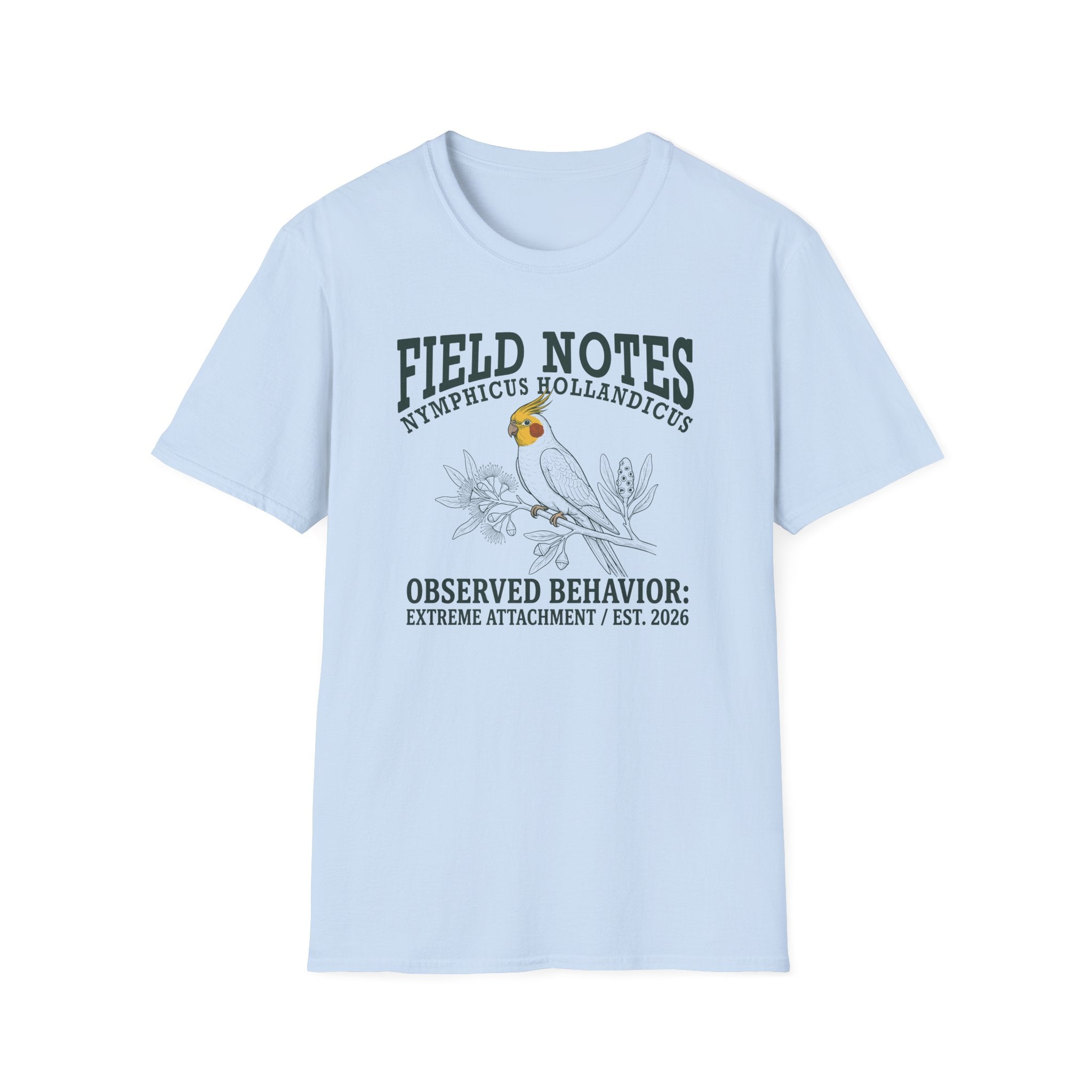 A light blue short-sleeve t-shirt with a graphic print on the front. The print features a parrot bird and the text 'FIELD NOTES', 'NYMPHICUS HOLLANDICUS', and 'OBSERVED BEHAVIOR: EXTREME ATTACHMENT / EST.