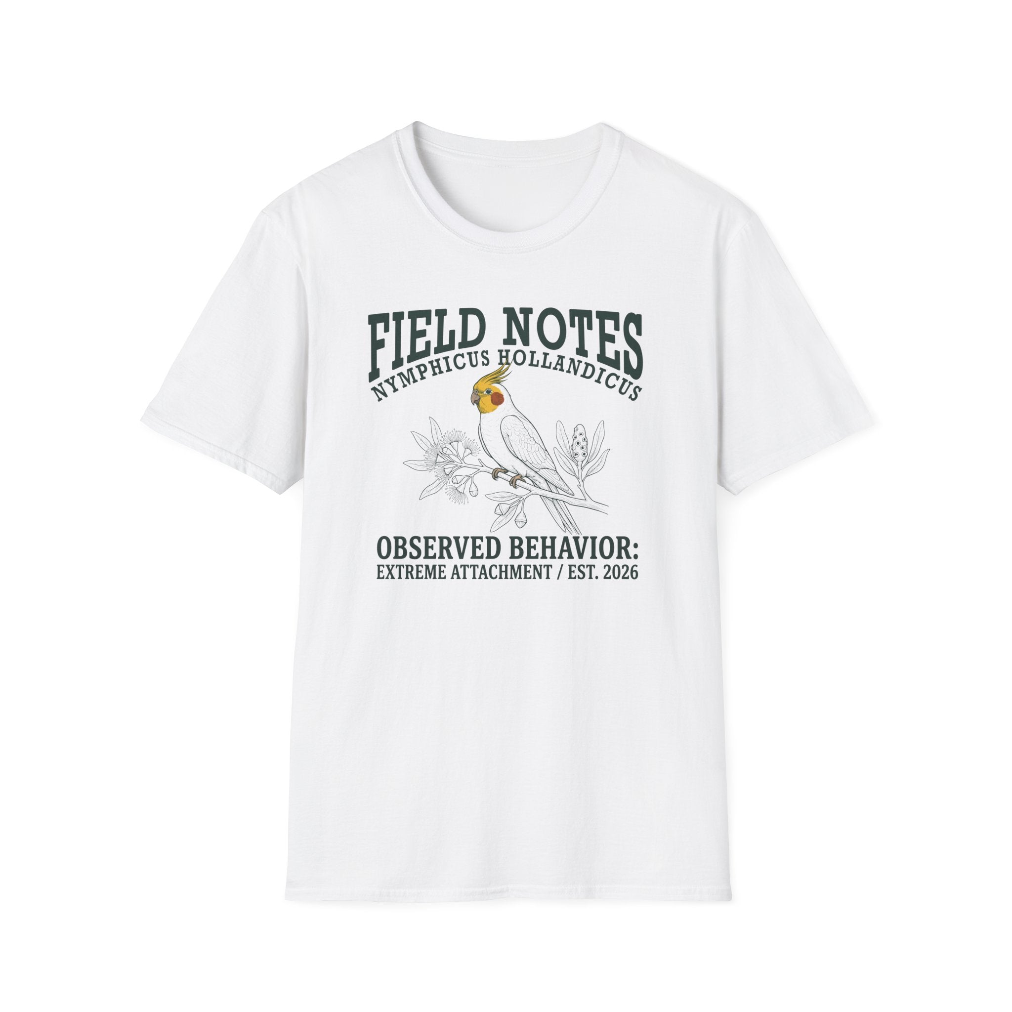 A white short-sleeve crewneck t-shirt featuring a dark green and black graphic print of a cockatel with the text 'FIELD NOTES NEMPLICUS HOLLANDICUS' and 'OBSERVED BEHAVIOR: EXTREME ATTACHMENT / EST. 2026'.